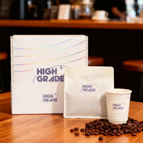 Premium-Kaffeebox mit individueller Marke, präsentiert mit Kaffeebeutel und -tasse in einer Café-Umgebung