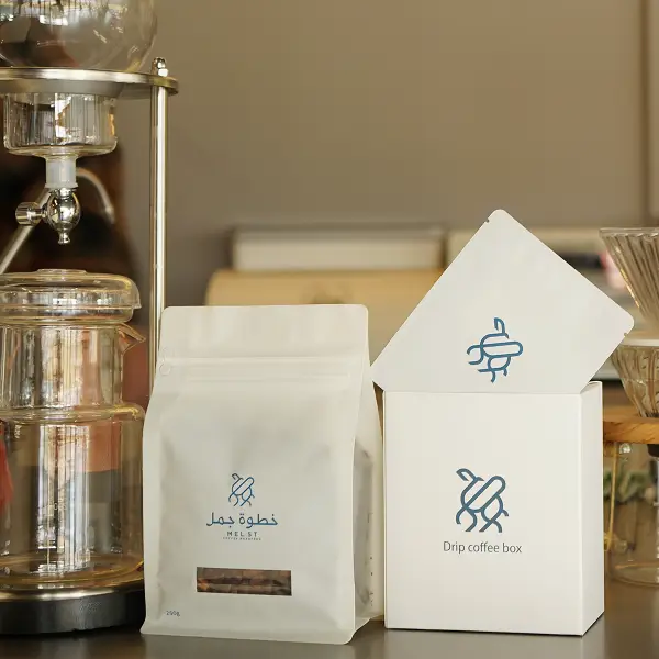 Premium, maßgefertigte Papierboxen und Kaffeebeutel, die in einem Café zur Branding-Präsentation gezeigt werden