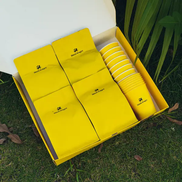 Innenansicht einer maßgefertigten Papier-Kaffeebox mit ordentlich arrangierten Kaffeebeuteln und -tassen