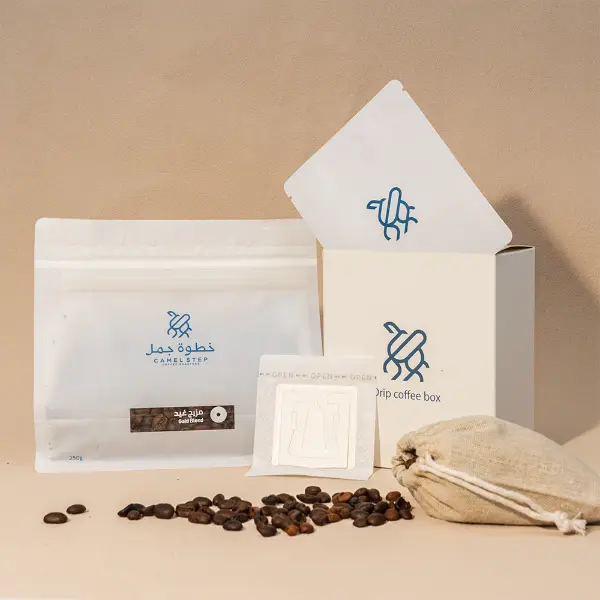 Individuell bedruckte Papierschachtel mit Kaffeetüten, Filterkaffee-Pack, und Bohnen in einem sauberen Studio-Setup