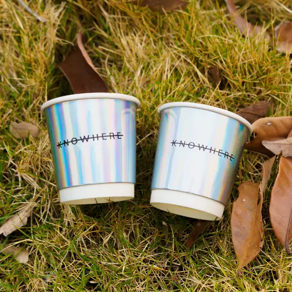 Holografische Pappbecher mit Regenbogenfolie in der Outdoor-Lifestyle-Szene